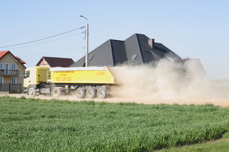 Tir jadący ulicą zostawia za sobą chmurę kurzu (Czytelnik)